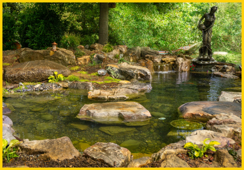 Charlotte, NC custom backyard pond with triple-tier waterfall, natural stone boulders, and signature fountain feature by Pondscapes of Charlotte—leaders in luxury water features