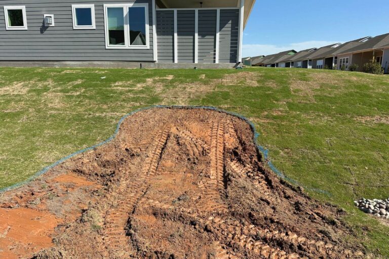 Backyard pond site prepared with grass removed, showing bare dirt ready for installation in Encore at Streamside, Waxhaw, NC.