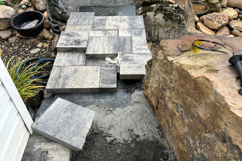 Pondscapes of Charlotte constructing a custom bridge over a koi pond during pond installation in Wesley Chapel, North Carolina