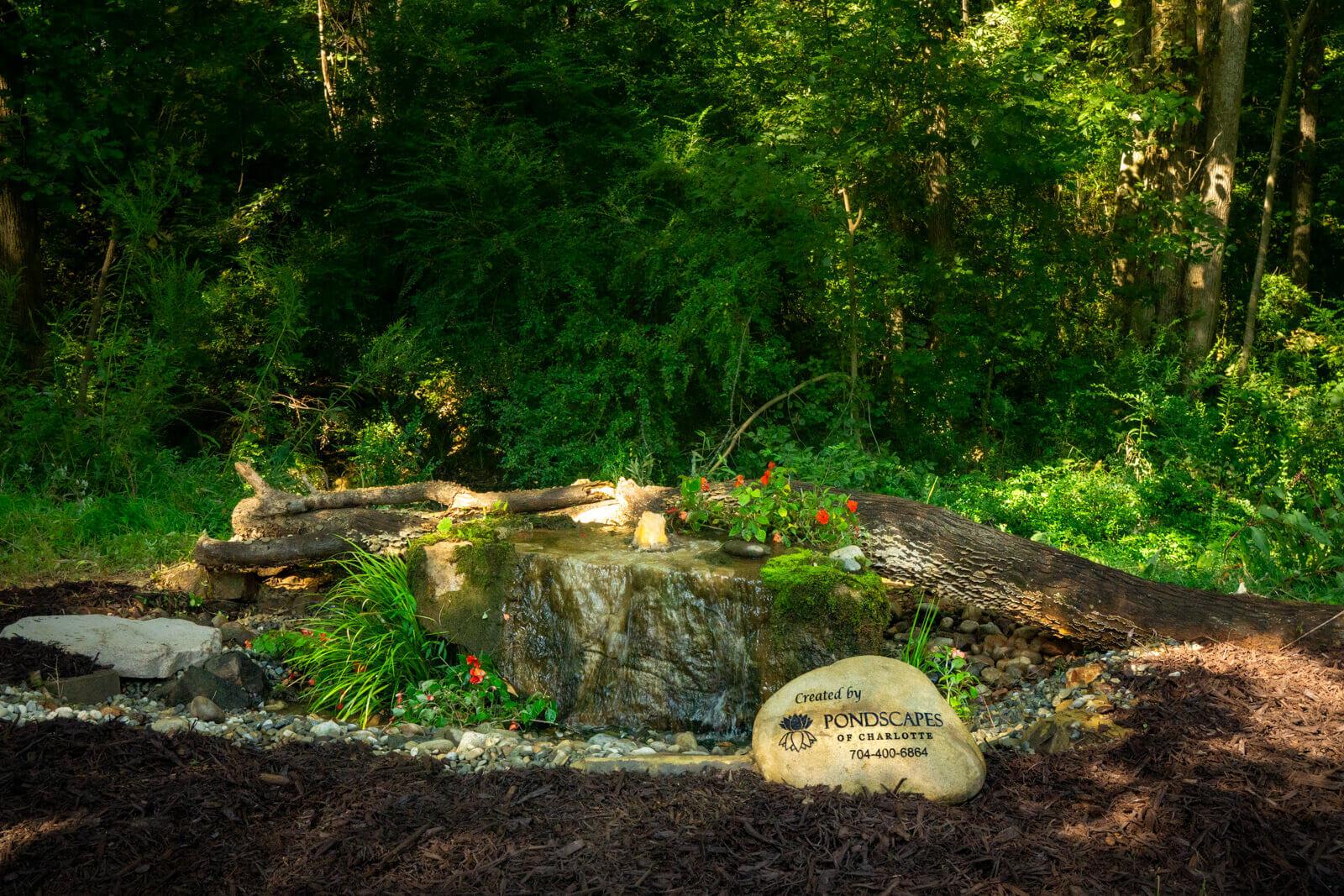 Beautiful bubbling boulder water feature installed by Pondscapes of Charlotte, featuring natural stone with water gently bubbling over the surface, creating a peaceful focal point for landscaping