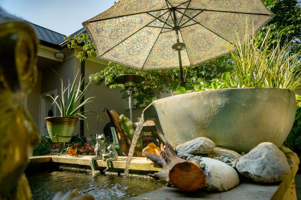 Custom spillway bowl water feature integrated into existing koi pond landscape, in South Park