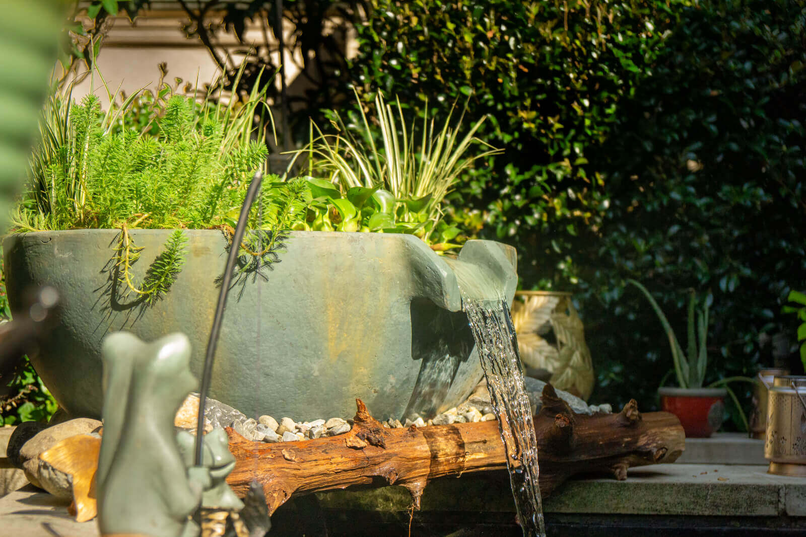 Professional pond technicians carefully positioning Aquascape spillway bowl during koi pond enhancement project in South Park, Charlotte