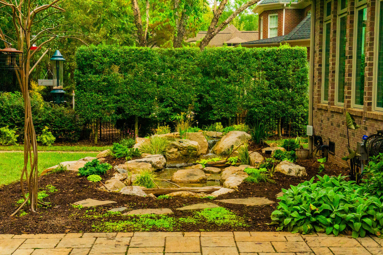 Natural stone waterfall and stream installation with landscaping in Marvin NC backyard