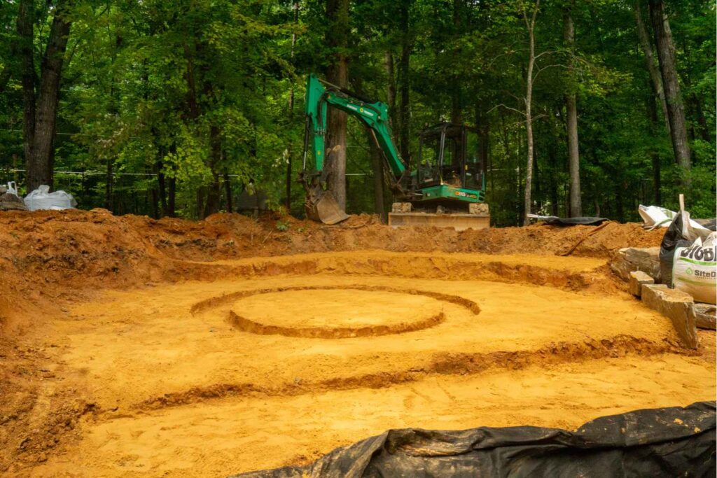 Excavation for backyard waterfall installation with patio and fire feature in Weddington NC
