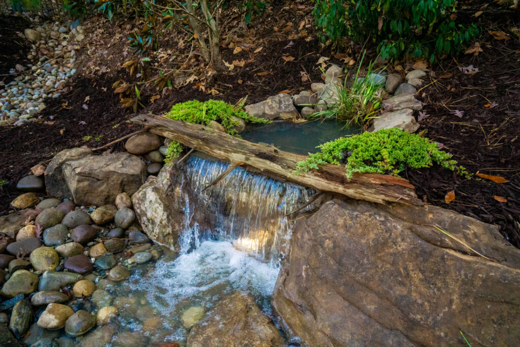 Pondless waterfall with driftwood and moss landscape design overhead view Fort Mill SC