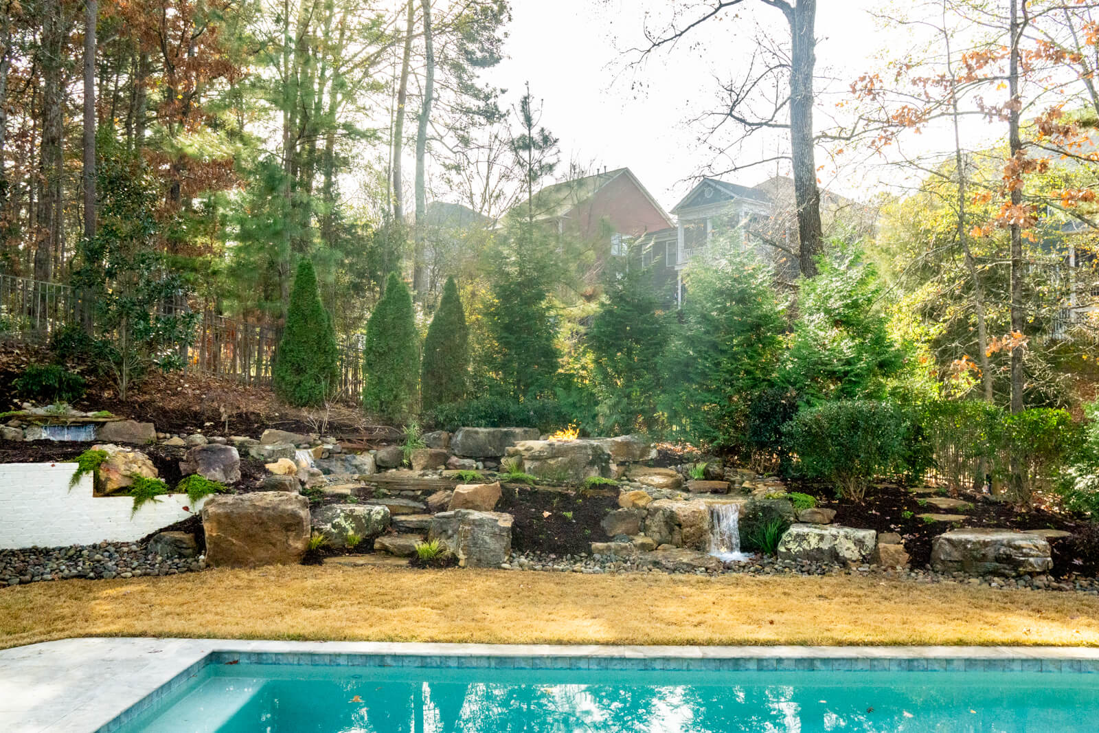 Backyard waterfall installation with fire pit and natural boulders Fort Mill SC