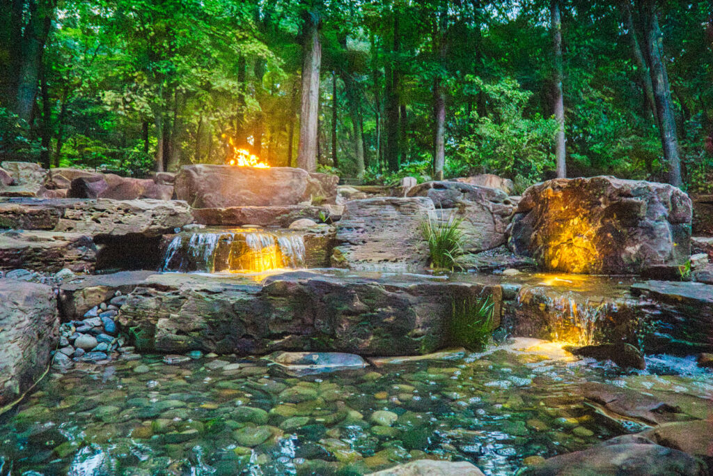 Backyard pondless waterfall with fire pit and lighting