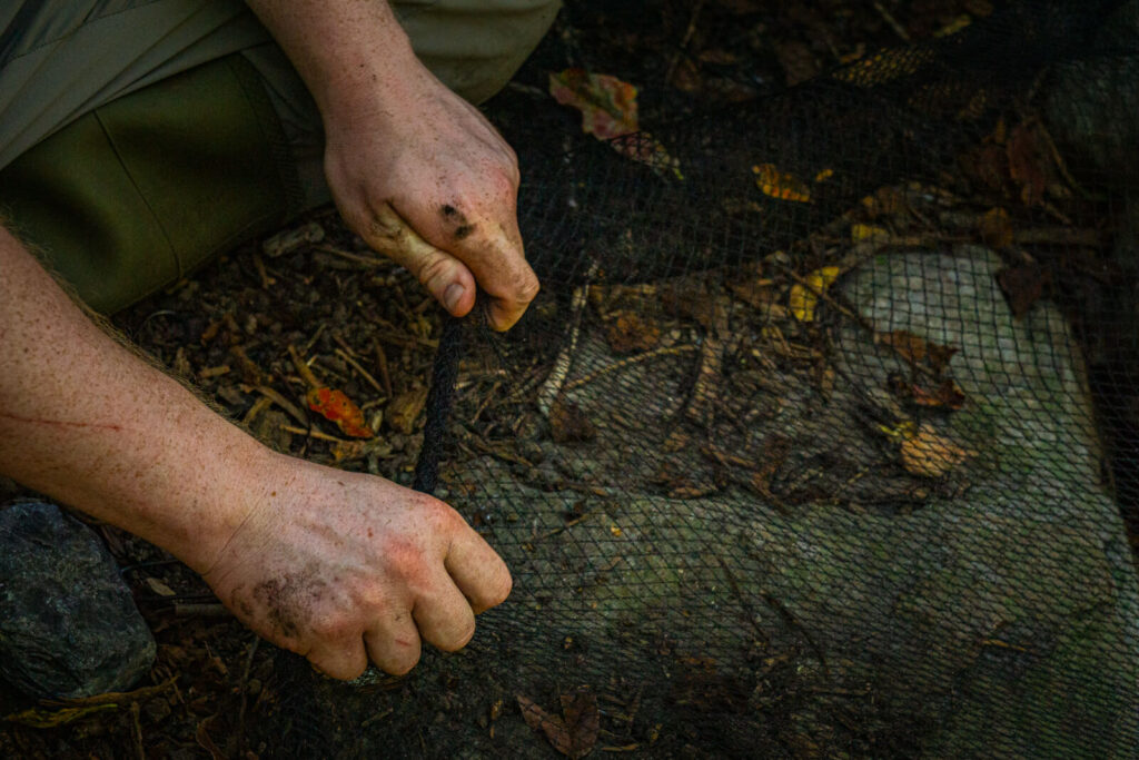 Expert technician installing net covering on water feature