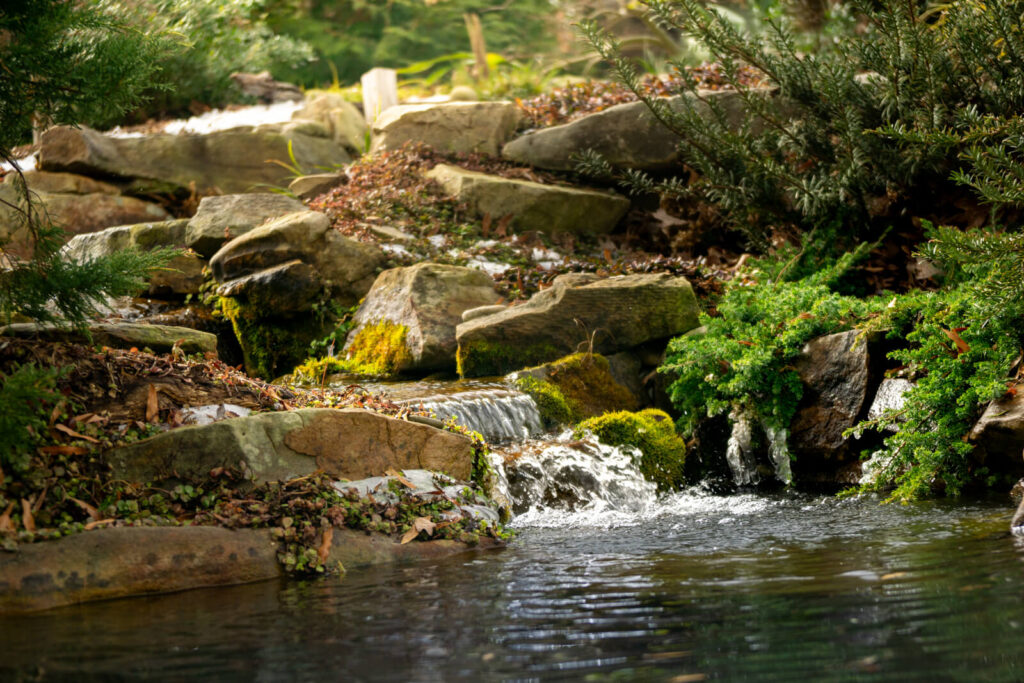 Natural stone waterfall during winter pond maintenance in Charlotte