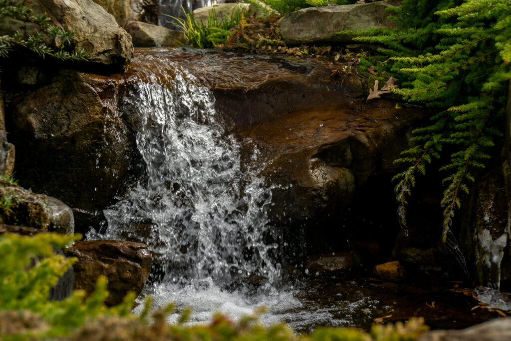Close up view of waterfall during winter pond maintenance