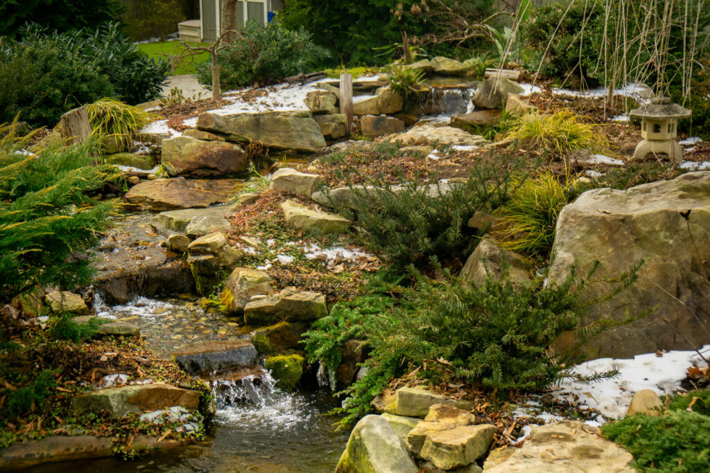 Natural stone stream during winter pond service in Charlotte