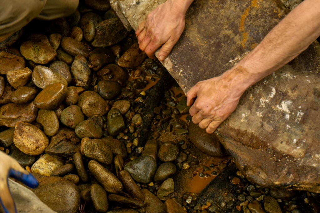 Pond builder lowering boulder into pond in Matthews, NC