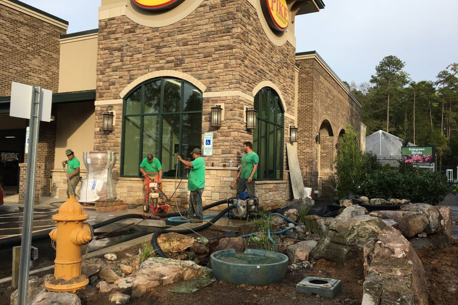 Pondscapes of Charlotte crew cleaning out newly finished commercial pond and water feature at Pike Nurseries Matthews NC