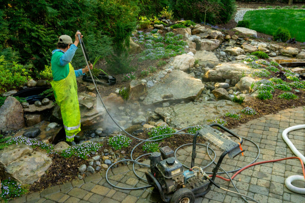 Vicente Pressure Washing and cleaning a water feature during a Quarterly VIP Service