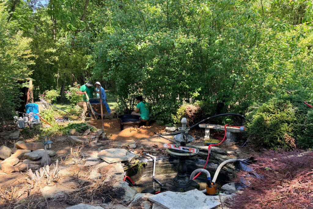 Wheelbarrowing in dirt to build up berm for waterfall