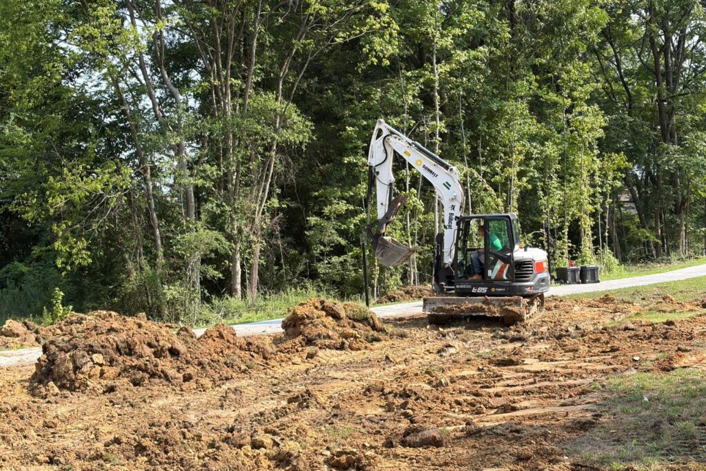 Moving dirt with excavator to open space for pond construction to start in Marvin, NC.