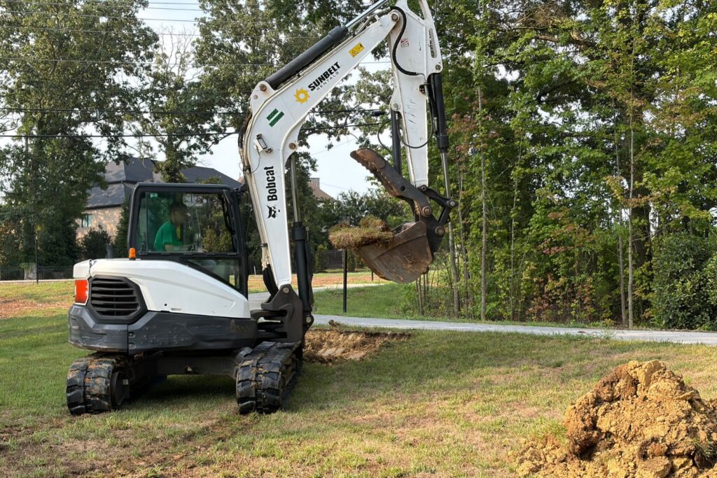Crew member maneuvering excavator on site at Village of Marvin, in NC.