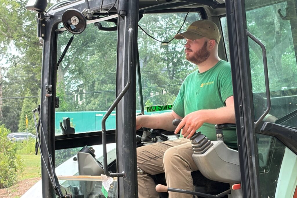 Crew member maneuvering the excavator at the job site.